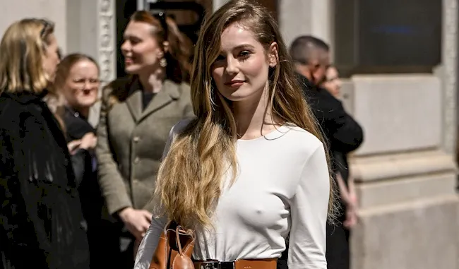 Pretty actress braless and posing outside in a white dress. Her nipple pokies are visible