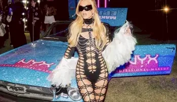 Fit blonde wearing a sexy and revealing bodysuit while posing on the hood of a colorful car